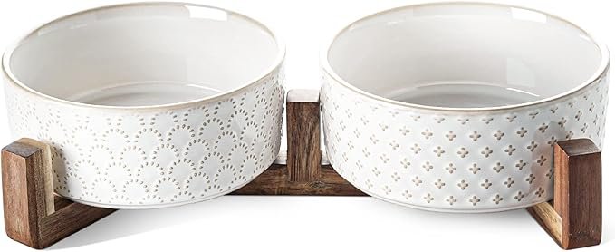 Picture of two white ceramic bowls held up by a brown wooden server for dogs