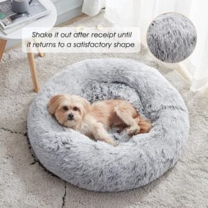 Picture of a small fluffy dog laying nice and comfy in a gray fluffy and cozy dog bed.
