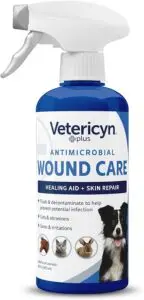 Vetericyn Plus Antimicrobial Wound Care spray bottle for pets. Blue and white label reads 'Healing Aid + Skin Repair' and lists uses including flushing, decontaminating, and helping prevent infection from cuts, abrasions, sores, and irritations. Safe for all animals with images of a dog, cat, rabbit, and horse.