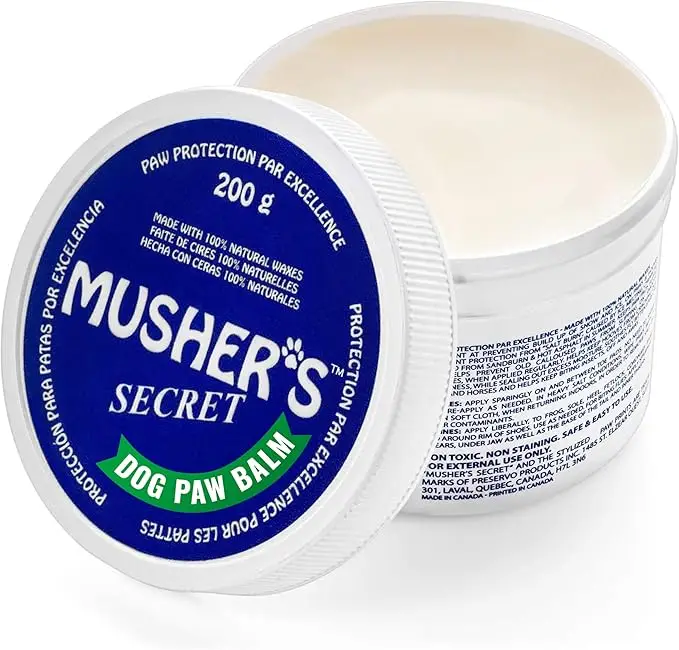 Musher’s Secret dog paw balm in a white container with blue lid — a protective paw care essential in fall essentials for dogs 2025.